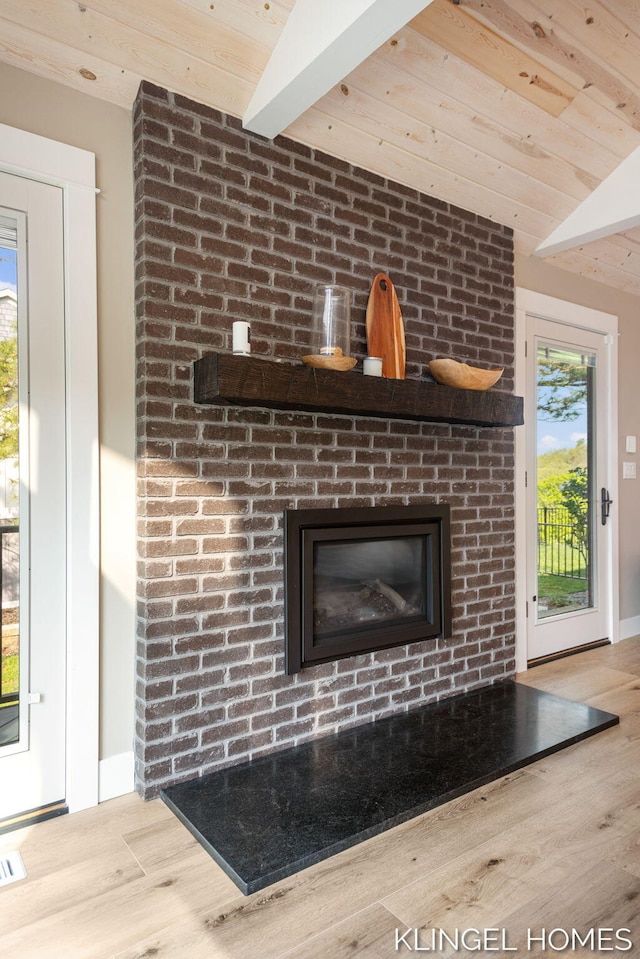 127 Emmet St, Grand Haven, MI 49417 - detailed view of wooden ceiling with exposed beams, wood finished floors, baseboards, and a fireplace