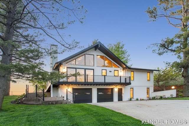 127 Emmet St, Grand Haven, MI 49417 - back of property at dusk featuring a chimney, a garage, driveway, a yard, and a balcony