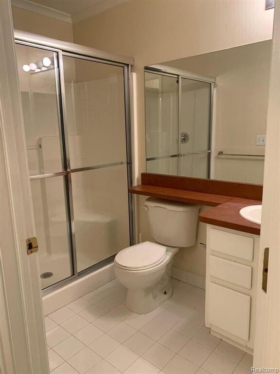 1240 University Dr Unit 2, Pontiac, MI 48342 - bathroom with tile patterned floors, vanity, a stall shower, toilet, and crown molding