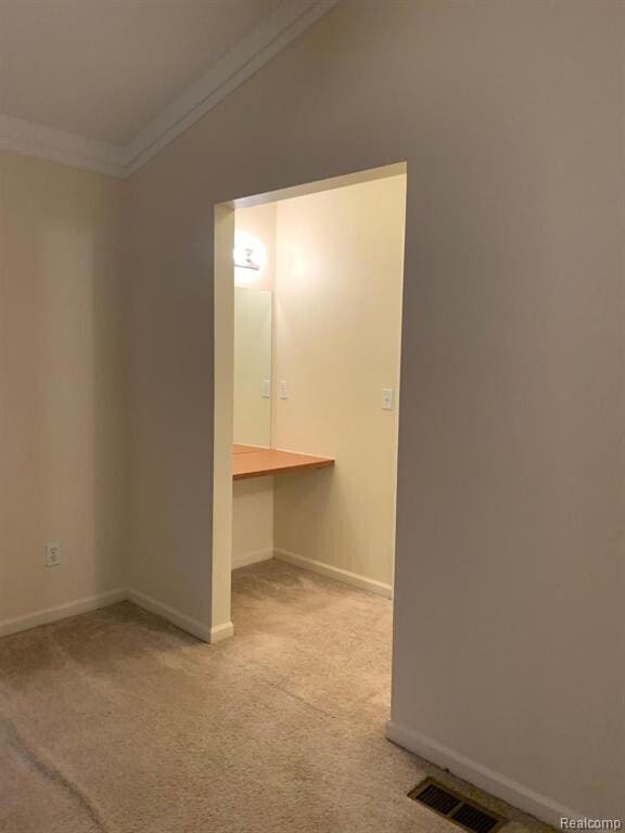 1240 University Dr Unit 2, Pontiac, MI 48342 - spare room featuring ornamental molding, light carpet, lofted ceiling, and baseboards