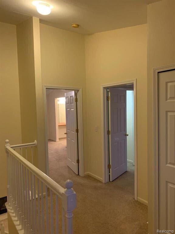 1240 University Dr Unit 2, Pontiac, MI 48342 - hallway with an upstairs landing, light carpet, and baseboards