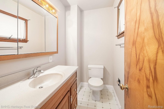 3226 Glasgow Dr, Lansing, MI 48911 - bathroom featuring vanity, toilet, baseboards, and plenty of natural light