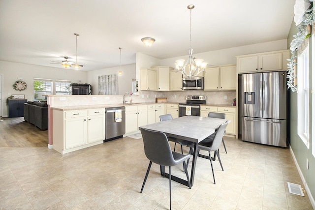 8825 Aveling Way, Richland, MI 49083 - kitchen featuring appliances with stainless steel finishes, a sink, a peninsula, a chandelier, and light countertops