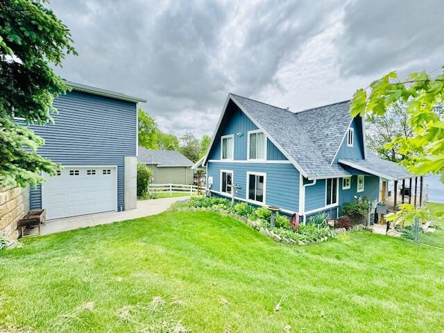 1022 Ottland Shrs, Lake Odessa, MI 48849 - back of property featuring a garage and a shingled roof