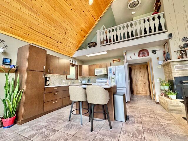 1022 Ottland Shrs, Lake Odessa, MI 48849 - kitchen with white appliances, high vaulted ceiling, wooden ceiling, light countertops, and a kitchen island