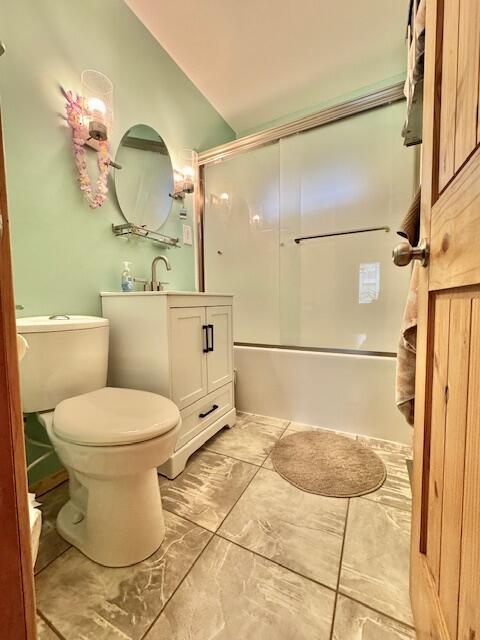 1022 Ottland Shrs, Lake Odessa, MI 48849 - full bath with toilet, vanity, combined bath / shower with glass door, lofted ceiling, and marble look tile flooring
