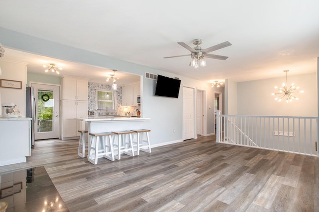 7920 8 1/2 Mile Rd, Ceresco, MI 49033 - unfurnished living room with light wood-style floors, a chandelier, and a ceiling fan