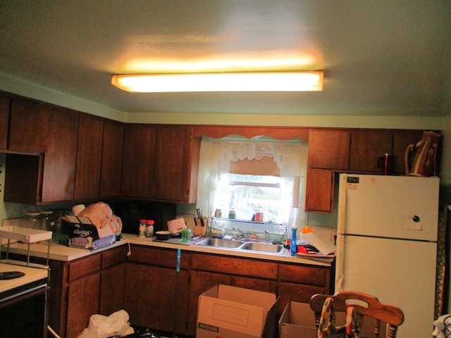 312 Leland St, Flushing, MI 48433 - kitchen with freestanding refrigerator, a sink, electric range oven, and light countertops
