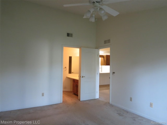 35707 Hunter Ave Unit 8, Westland, MI 48185 - unfurnished bedroom with a towering ceiling, light carpet, ensuite bath, and ceiling fan