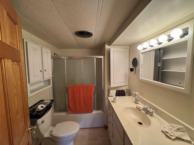 7215 E Niemitalo Dr, Chase, MI 49623 - full bathroom featuring vanity, a textured ceiling, toilet, enclosed tub / shower combo, and wood finished floors