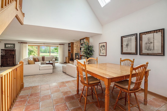 9095 S Saginaw Rd Unit 10, Grand Blanc, MI 48439 - dining space with high vaulted ceiling, a skylight, baseboards, and a fireplace