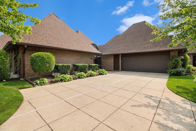 9095 S Saginaw Rd Unit 10, Grand Blanc, MI 48439 - view of front facade featuring brick siding, concrete driveway, a garage, and a shingled roof