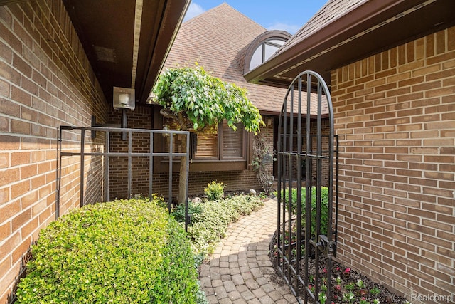9095 S Saginaw Rd Unit 10, Grand Blanc, MI 48439 - doorway to property with brick siding, a gate, and a shingled roof