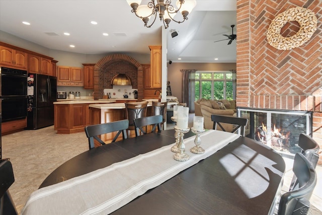 3283 Foxfire Dr, Milford, MI 48380 - dining space featuring a brick fireplace, a chandelier, recessed lighting, and a ceiling fan