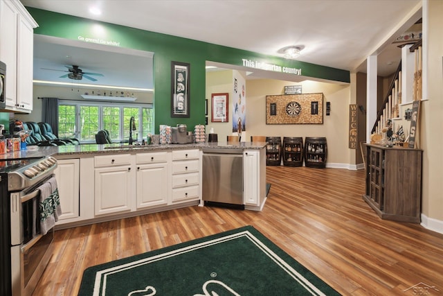 3283 Foxfire Dr, Milford, MI 48380 - kitchen featuring appliances with stainless steel finishes, a sink, light wood-style floors, white cabinetry, and ceiling fan