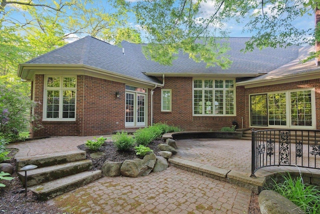 3283 Foxfire Dr, Milford, MI 48380 - rear view of house with a patio area, roof with shingles, and brick siding