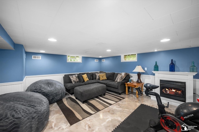 4851 Consear Rd, Ottawa Lake, MI 49267 - living room with finished concrete flooring, a wainscoted wall, and a glass covered fireplace