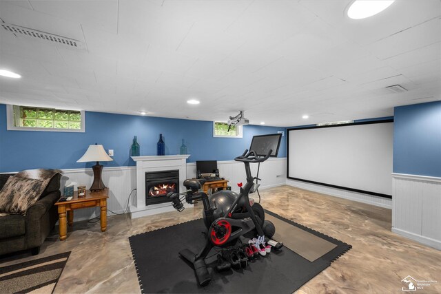4851 Consear Rd, Ottawa Lake, MI 49267 - exercise area featuring a warm lit fireplace and a wainscoted wall