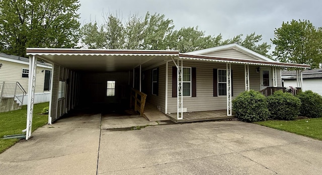 59 Clydesdale Dr, Mount Morris, MI 48458 - manufactured / mobile home with concrete driveway, an attached carport, covered porch, and a front lawn