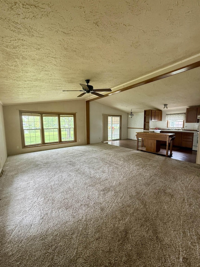 59 Clydesdale Dr, Mount Morris, MI 48458 - unfurnished living room with a textured ceiling, vaulted ceiling, dark carpet, and ceiling fan