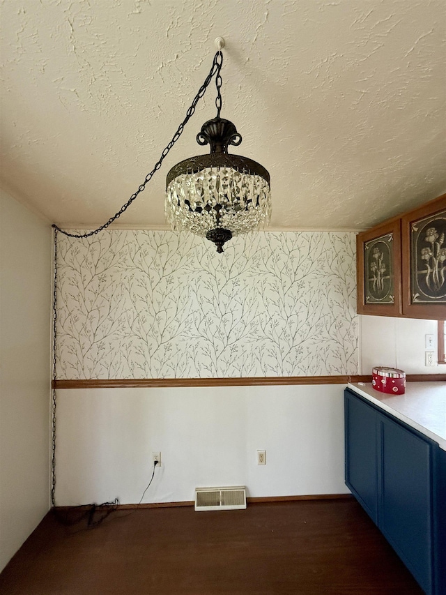 59 Clydesdale Dr, Mount Morris, MI 48458 - unfurnished dining area featuring a textured ceiling, wallpapered walls, and dark wood-style floors