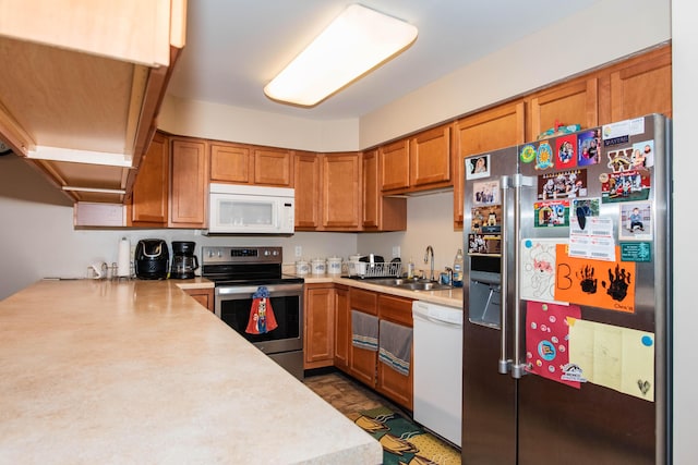 4164 W Centre Ave Unit 103, Portage, MI 49024 - kitchen featuring appliances with stainless steel finishes, a sink, brown cabinets, and light countertops