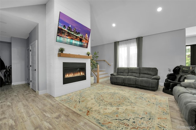 44200 Judd Rd, Belleville, MI 48111 - living room featuring wood finished floors, recessed lighting, a large fireplace, lofted ceiling, and baseboards