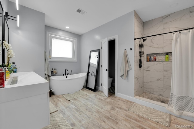 44200 Judd Rd, Belleville, MI 48111 - bathroom with a marble finish shower, a freestanding tub, wood finished floors, vanity, and toilet