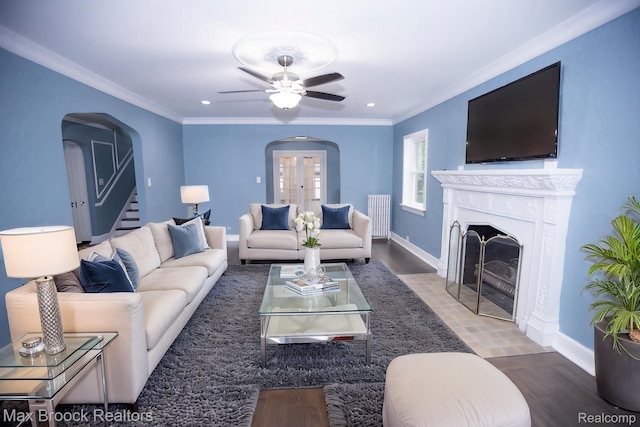 17352 Parkside St, Detroit, MI 48221 - living area with arched walkways, ceiling fan, crown molding, baseboards, and a fireplace with flush hearth