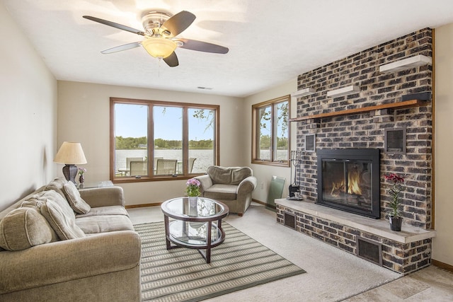 8928 Ellis St SE, Alto, MI 49302 - living room featuring a brick fireplace, ceiling fan, baseboards, and a water view