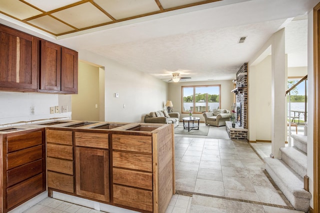 8928 Ellis St SE, Alto, MI 49302 - kitchen featuring open floor plan, brown cabinets, a ceiling fan, and a textured ceiling