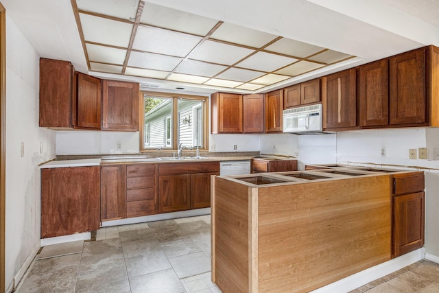 8928 Ellis St SE, Alto, MI 49302 - kitchen featuring white appliances, a sink, baseboards, and brown cabinetry