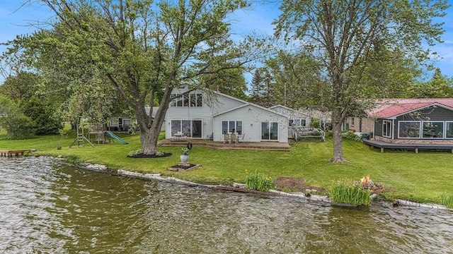 8928 Ellis St SE, Alto, MI 49302 - rear view of house with a fire pit, a playground, a deck with water view, and a yard