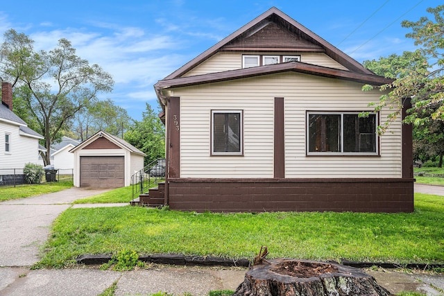 393 Merrill Ave, Muskegon, MI 49441 - view of home's exterior featuring a garage, driveway, an outdoor structure, and a lawn