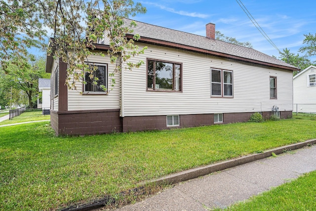 393 Merrill Ave, Muskegon, MI 49441 - view of property exterior with a lawn, a chimney, and a shingled roof