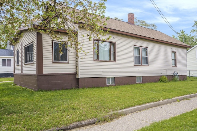 393 Merrill Ave, Muskegon, MI 49441 - view of property exterior with a yard, a chimney, and roof with shingles