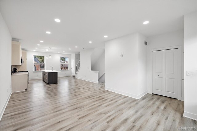 2817 Summers Pl, Troy, MI 48084 - unfurnished living room featuring a sink, recessed lighting, light wood-style floors, baseboards, and stairs