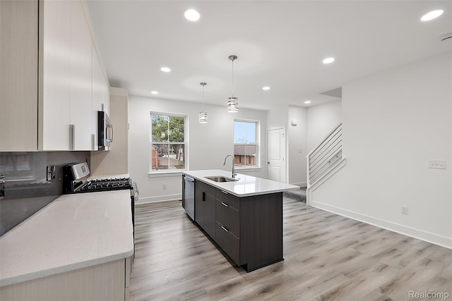 2817 Summers Pl, Troy, MI 48084 - kitchen featuring a sink, stainless steel appliances, a center island with sink, baseboards, and light wood finished floors