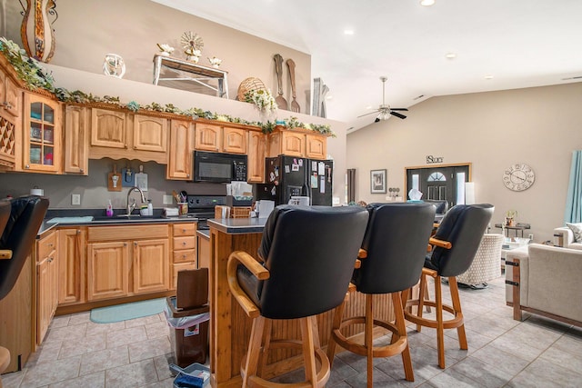 390 Iyopawa Rd, Coldwater, MI 49036 - kitchen featuring black appliances, a sink, a ceiling fan, dark countertops, and a center island
