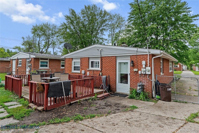 7953 Elm St, Taylor, MI 48180 - rear view of house with a wooden deck, brick siding, and outdoor dining area