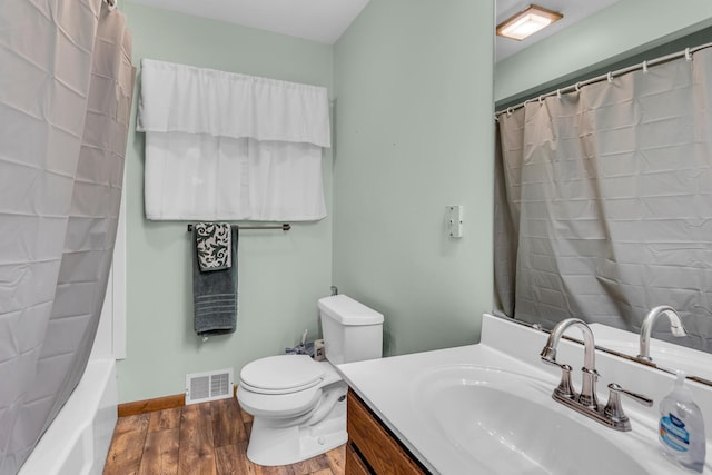 11245 Antcliff Rd, Brooklyn, MI 49230 - full bathroom featuring vanity, toilet, wood finished floors, baseboards, and shower / tub combo with curtain