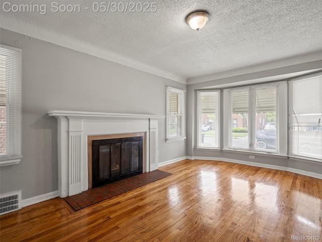 15058 Vaughan St, Detroit, MI 48223 - unfurnished living room with a textured ceiling, wood finished floors, a fireplace with flush hearth, and baseboards