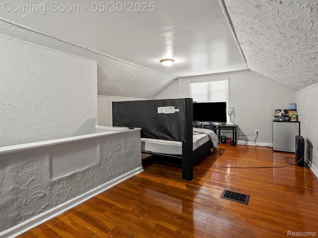 15058 Vaughan St, Detroit, MI 48223 - bedroom featuring hardwood / wood-style flooring, vaulted ceiling, fridge, baseboards, and a textured wall