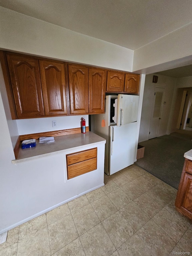 34245 Shawnee St, Westland, MI 48185 - kitchen featuring freestanding refrigerator, brown cabinetry, and light countertops