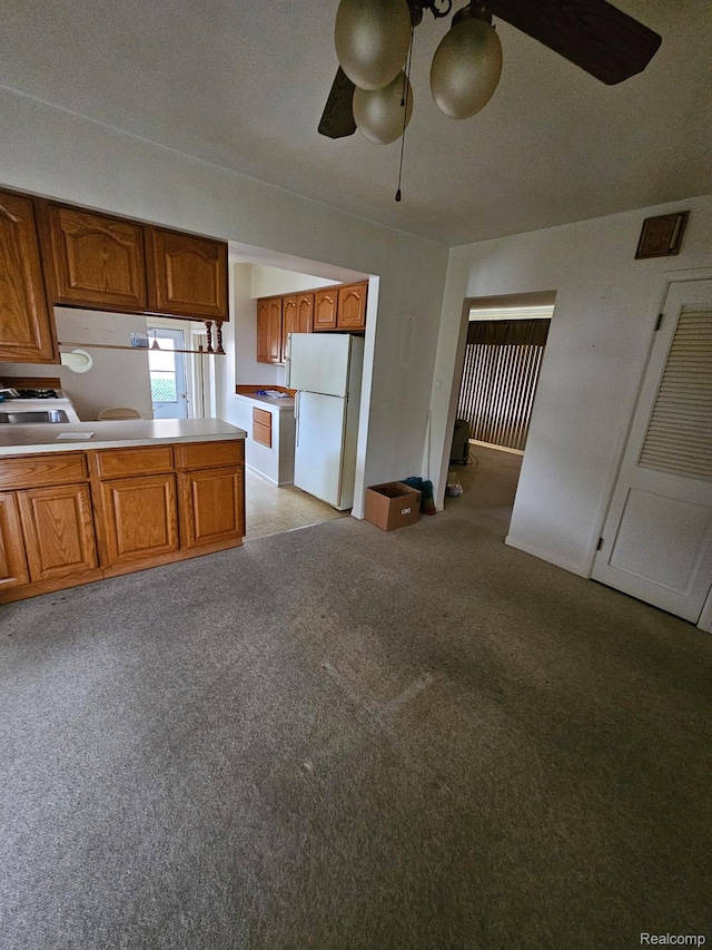 34245 Shawnee St, Westland, MI 48185 - kitchen featuring freestanding refrigerator, ceiling fan, brown cabinetry, and light carpet