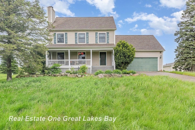 2203 Bullock Rd, Lapeer, MI 48446 - colonial house featuring a chimney, asphalt driveway, covered porch, and an attached garage