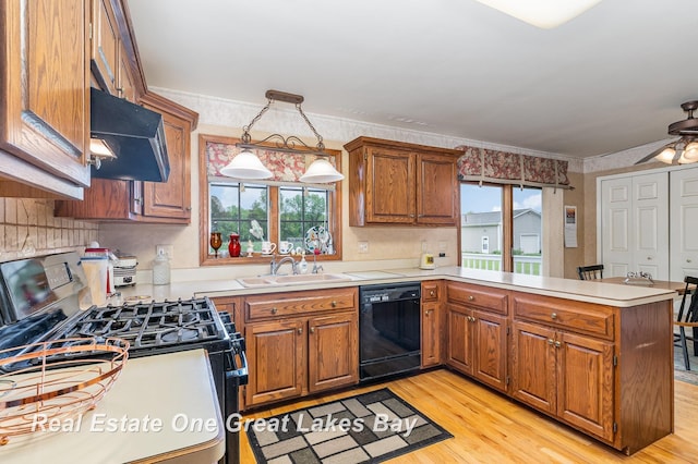 2203 Bullock Rd, Lapeer, MI 48446 - kitchen with black dishwasher, range with gas stovetop, extractor fan, a peninsula, and brown cabinetry