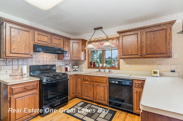 2203 Bullock Rd, Lapeer, MI 48446 - kitchen with black appliances, under cabinet range hood, a sink, light wood-style flooring, and light countertops