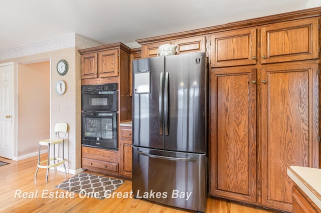 2203 Bullock Rd, Lapeer, MI 48446 - kitchen featuring freestanding refrigerator, brown cabinetry, baseboards, and light wood-style floors