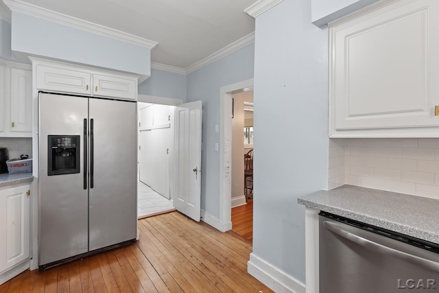 2803 Spielman Rd, Adrian, MI 49221 - kitchen with appliances with stainless steel finishes, ornamental molding, light wood-style floors, white cabinetry, and backsplash